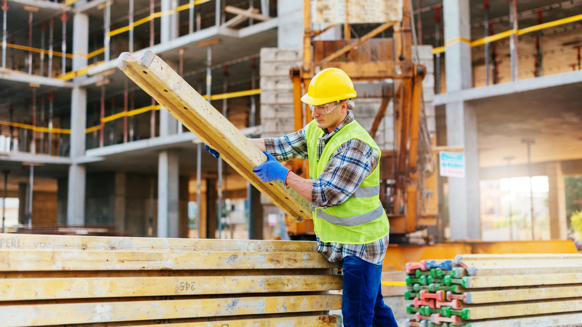 Construction worker transporting building materials on a construction site, highlighting the importance of Commercial General Liability (CGL) insurance for protecting construction companies from potential risks and liabilities.